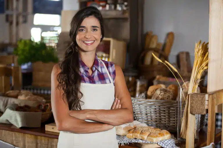 retrato-de-uma-funcionaria-sorridente-em-pe-com-os-bracos-cruzados-na-padaria
