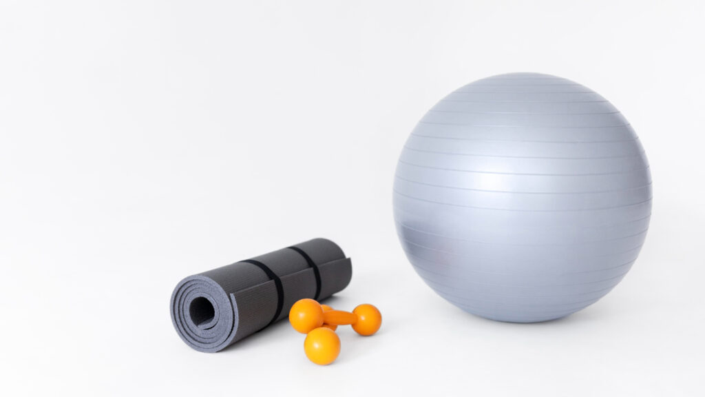 Material para pilates: Bola Suiça, tapete e halteres.